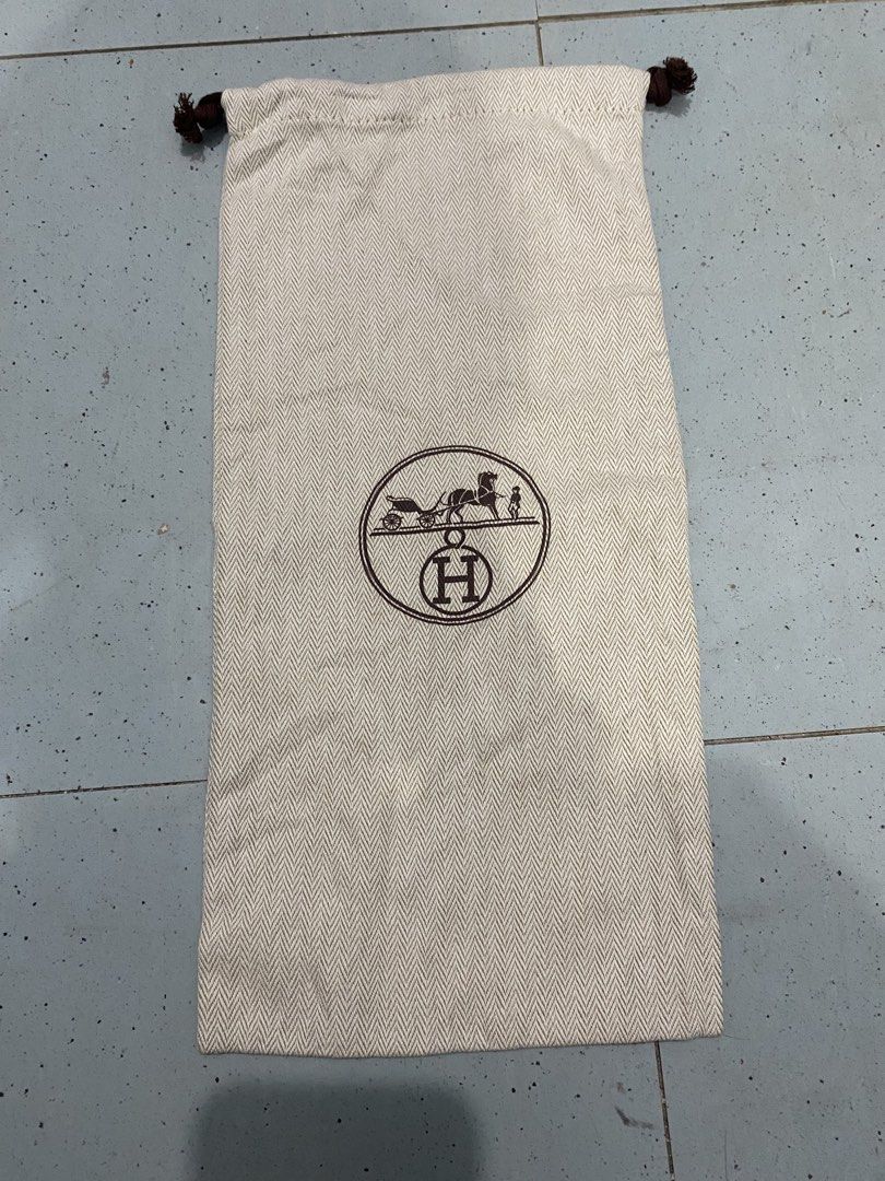 Hermes herringbone dust bag with drawstring (Category: Luxury Bags & Wallets) located in Davao. Submitted by dandeshop (Listing ID 1471089354, Image 1). Description: - 100% Authentic Hermes dust bag - Beige herringbone cotton material with brown silk-screened logo (horse, carriage, and H emblem) - Drawstring closure with dark brown knotted ends - Clean inside and out - Long rectangular shape, ideal for boots, tall items, or smaller bags - From a 