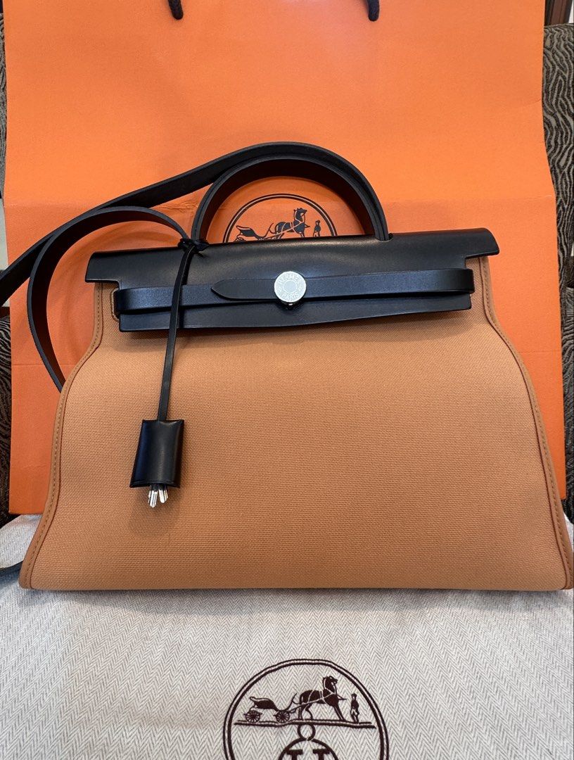 Hermès Herbag Zip Canvas and Leather Bag (Category: Luxury Bags & Wallets) located in Quezon City. Submitted by jose_toms (Listing ID 1470967476, Image 2). Description: - Brand: Hermès - Model: Herbag Zip - Color: Vibrant Orange canvas & Black leather - Hardware: Palladium - Features: Structured trapezoid silhouette, top handle, long shoulder strap, clochette with keys - Condition: Pristine, clean interior and exterior - Inclusions: Original oran