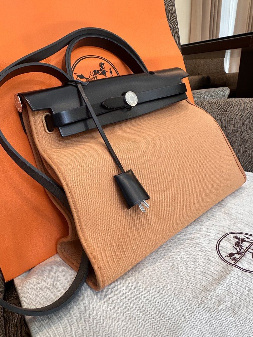 Hermès Herbag Zip Canvas and Leather Bag (Category: Luxury Bags & Wallets) located in Quezon City. Submitted by jose_toms (Listing ID 1470967476, Image 3). Description: - Brand: Hermès - Model: Herbag Zip - Color: Vibrant Orange canvas & Black leather - Hardware: Palladium - Features: Structured trapezoid silhouette, top handle, long shoulder strap, clochette with keys - Condition: Pristine, clean interior and exterior - Inclusions: Original oran