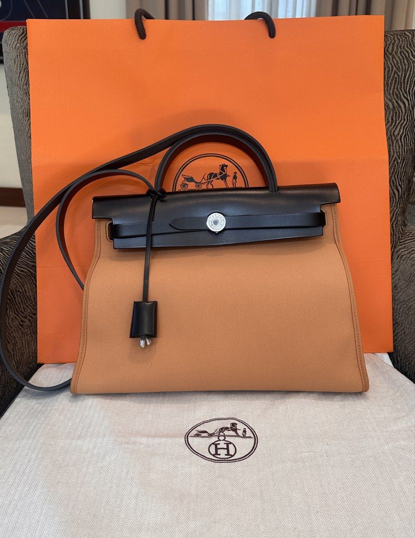 Hermès Herbag Zip Canvas and Leather Bag (Category: Luxury Bags & Wallets) located in Quezon City. Submitted by jose_toms (Listing ID 1470967476, Image 1). Description: - Brand: Hermès - Model: Herbag Zip - Color: Vibrant Orange canvas & Black leather - Hardware: Palladium - Features: Structured trapezoid silhouette, top handle, long shoulder strap, clochette with keys - Condition: Pristine, clean interior and exterior - Inclusions: Original oran