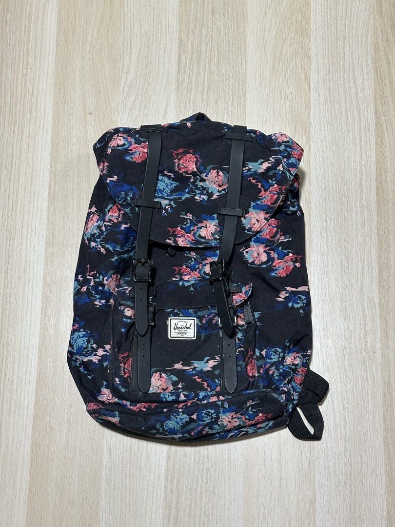 Herschel Supply Co. Floral Print Backpack (Category: Backpacks) located in Mandaluyong City. Submitted by supercleng (Listing ID 1471075965, Image 1). Description: - Brand: Herschel Supply Co. - Closure: Drawstring cinch top with magnetic buckle straps and adjustable metal hardware - Pockets: Convenient front zipped pocket with classic woven Herschel logo patch - Interior: Signature red and white striped fabric lining.