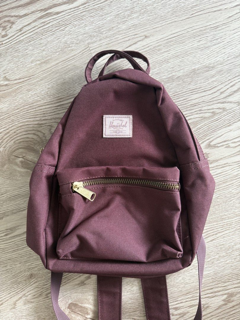 Herschel Supply Co. Nova Mini Backpack Plum Purple (Category: Backpacks) located in Pasig City. Submitted by anjeg (Listing ID 1470953652, Image 1). Description: - Brand: Herschel Supply Co. - Style: Mini Backpack - Color: Plum Purple - Features: Signature red and white striped fabric lining, front zip pocket with gold-tone hardware, dual top carrying handles, and adjustable shoulder straps - Condition: Clean inside and out - Perfect for: Daily e