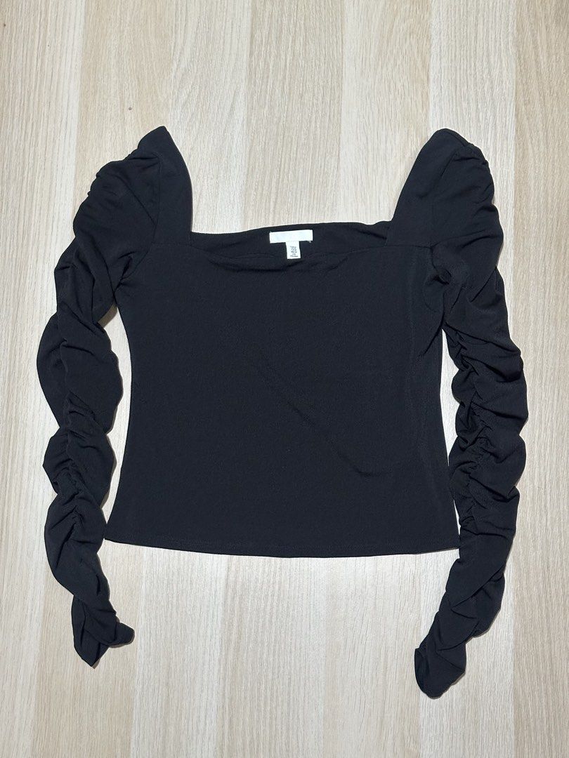 H&M Black Ruched Sleeve Top (Category: Blouses) located in Mandaluyong City. Submitted by supercleng (Listing ID 1471075266, Image 1). Description: - Brand: H&M - Size: M (EUR/US M) - Color: Black - Fit: Slim fit with stretchy fabric - Design: Square neckline, puffed shoulders, and heavy ruching down the long sleeves - Condition: Washed but unused.