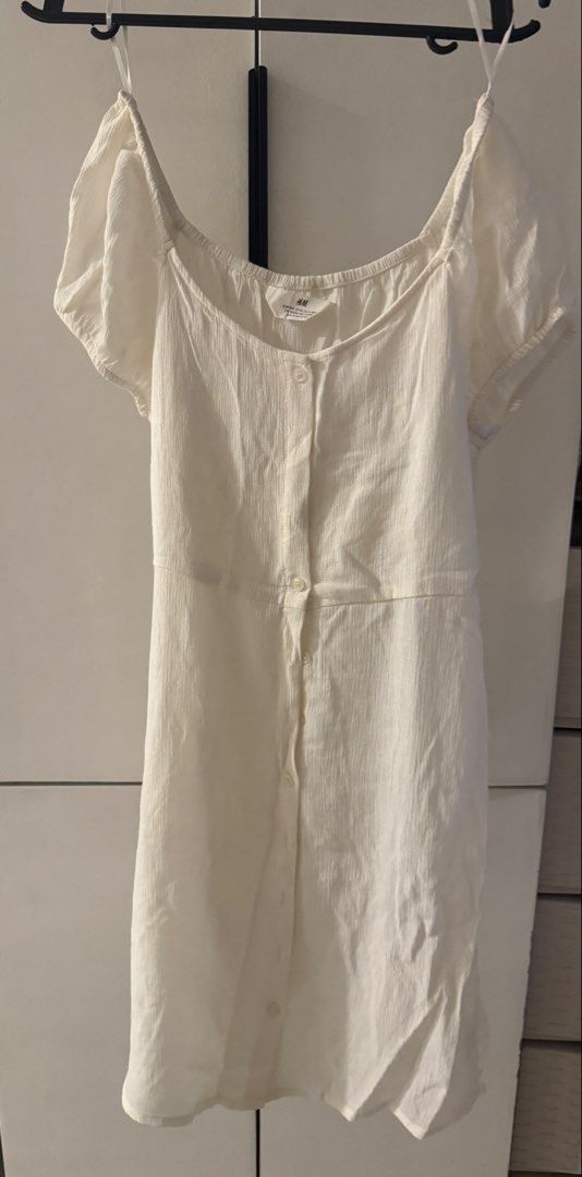 H&M White Button-Up Short Sleeve Dress (Category: Dresses) located in Valenzuela. Submitted by tricegonzales (Listing ID 1470991640, Image 1). Description: - Brand: H&M - Color: White - Style: Casual dress with scoop neckline and short puff sleeves - Details: Functional front button closure down the center, light textured fabric, and a fitted waist seam - Perfect for: Warm days, easily paired with sandals or sneakers - Condition: Excellent, size 