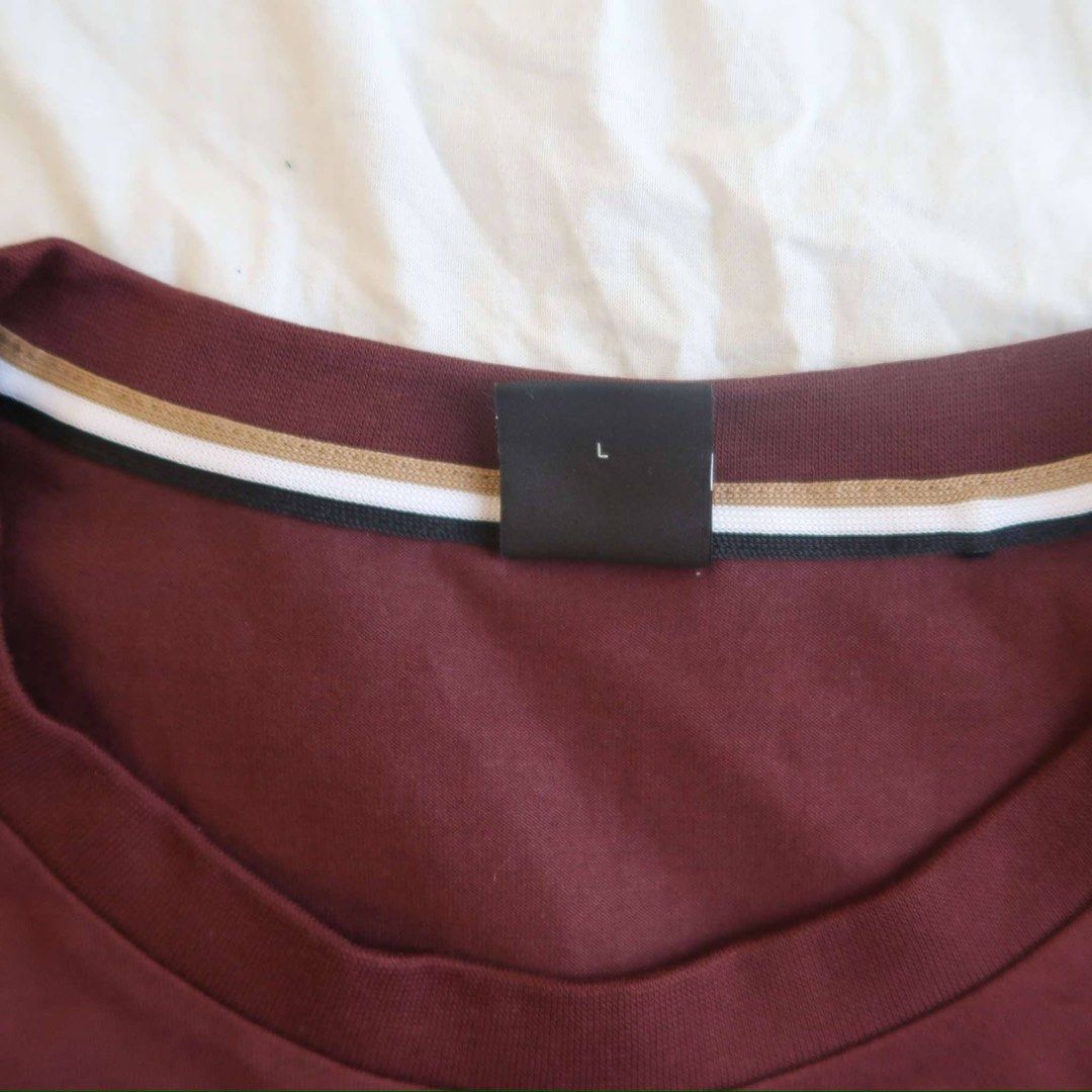 Hugo Boss Maroon T-Shirt Size L (Category: Tshirts & Polo Shirts ) located in Manila. Submitted by mixi_lexi (Listing ID 1471018406, Image 2). Description: - Brand: Hugo Boss - Color: Maroon with multi-color diagonal chest stripe and branding - Size: Large - Neckline: Crew neck with brown, white, and black striped ribbed collar - Sleeves: Short sleeves - Condition: Brand new/Mint - Style: Casual / Designer streetwear - Meetup or shipping options 