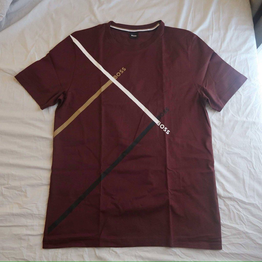 Hugo Boss Maroon T-Shirt Size L (Category: Tshirts & Polo Shirts ) located in Manila. Submitted by mixi_lexi (Listing ID 1471018406, Image 1). Description: - Brand: Hugo Boss - Color: Maroon with multi-color diagonal chest stripe and branding - Size: Large - Neckline: Crew neck with brown, white, and black striped ribbed collar - Sleeves: Short sleeves - Condition: Brand new/Mint - Style: Casual / Designer streetwear - Meetup or shipping options 