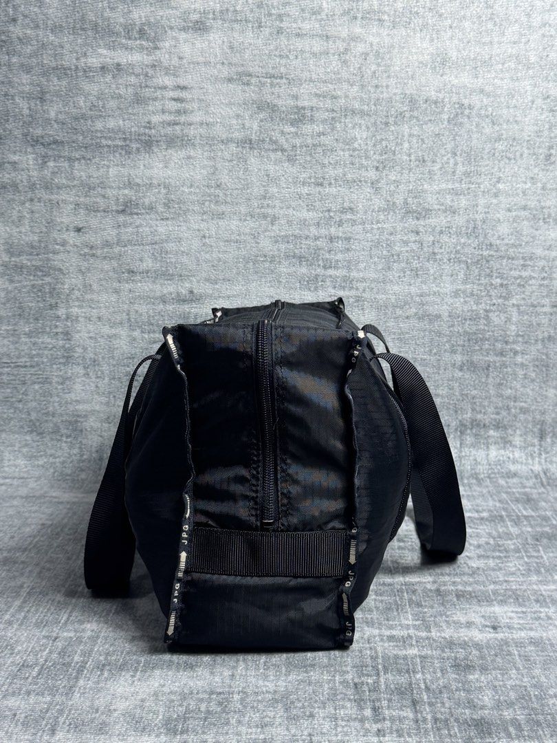 Jean Paul Gaultier - Weekender Nylon Bag (Category: Briefcases) located in Manila. Submitted by members-only (Listing ID 1471076628, Image 2). Description: JPG Nylon Duffle Bag In good condition No major issue Flaws: Faded JPG print in front Check pics for details JPG arrow zipper No holes.