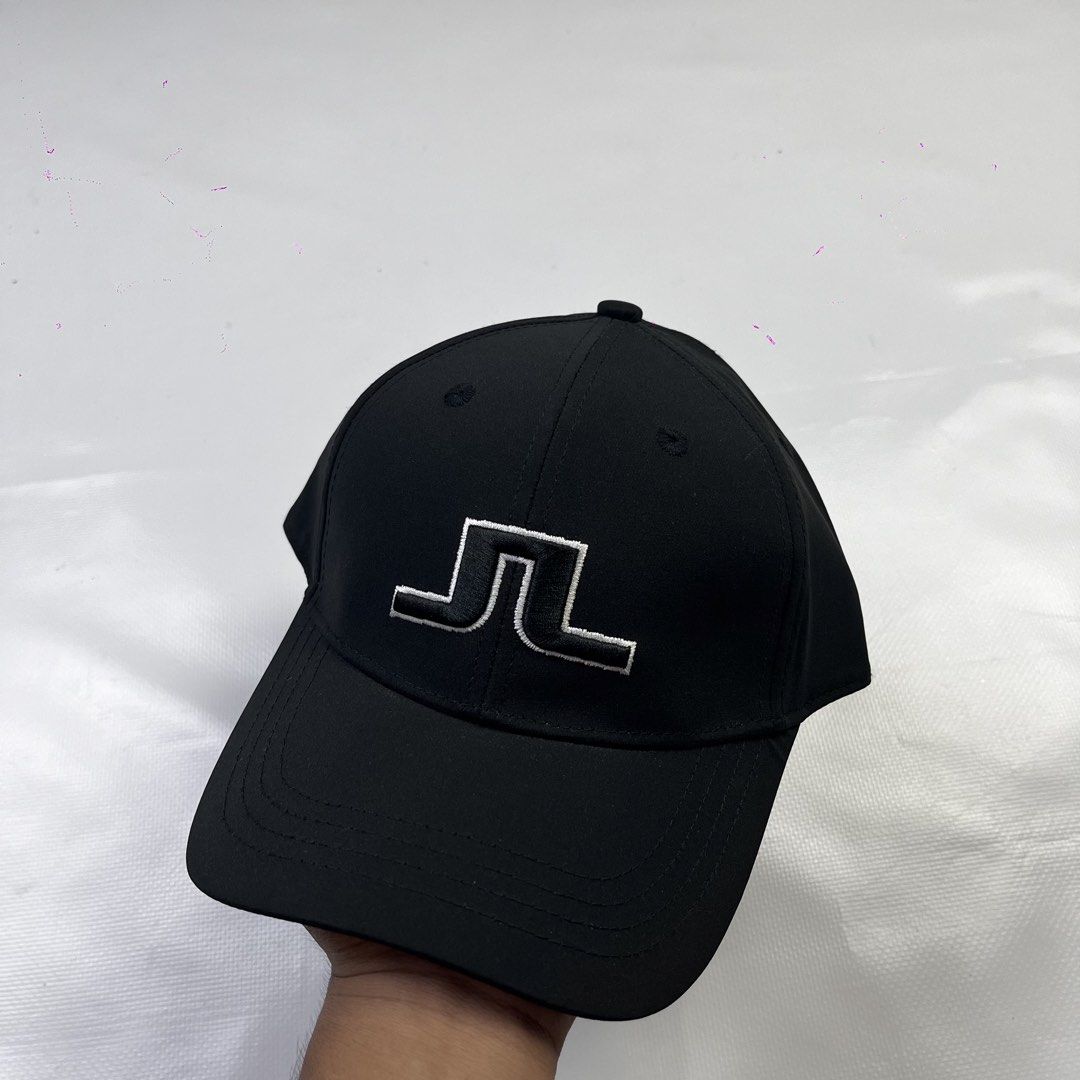 j.lindeberg Black Golf Cap Hat (Category: Caps & Hats) located in Lucena. Submitted by nifty_finds (Listing ID 1470976854, Image 1). Description: - Brand: J.Lindeberg - Condition: Brand new with hang tag attached - Color: Classic black with white embroidered logo on the front - Fit: One size fits most with an adjustable strap and branded metal clasp - Details: Features interior brand and size labels with clean stitching all around.
