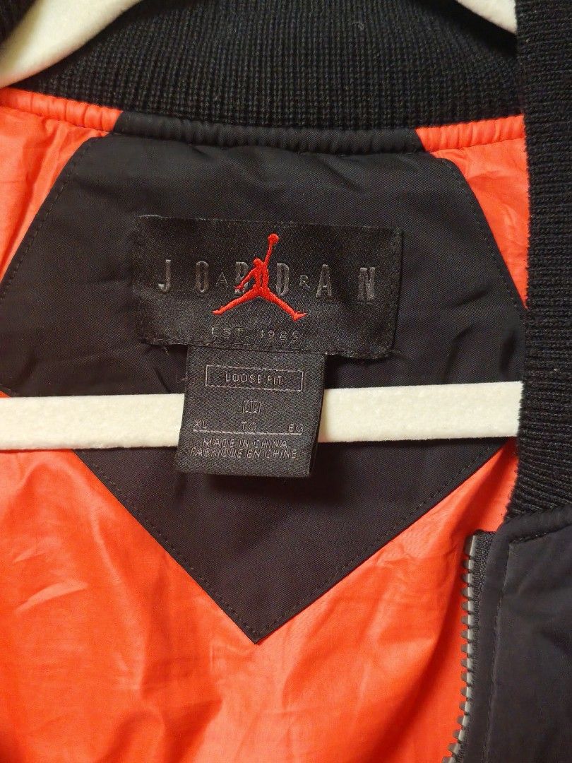 Jordan Black Bomber Jacket Size XL (Category: Coats, Jackets and Outerwear) located in Manila. Submitted by ggclothings (Listing ID 1470972052, Image 3). Description: - Brand: Jordan - Item: Bomber Jacket - Color: Black with bright orange lining - Size: XL (Loose fit) - Style Code: CK6669-010 - Features: Heavy duty front zipper, chest and sleeve utility pockets, reflective Air Jordan lettering on the back - Condition: Clean inside and out, warm w