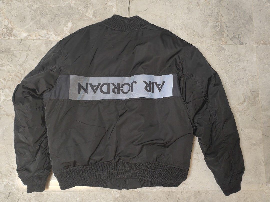 Jordan Black Bomber Jacket Size XL (Category: Coats, Jackets and Outerwear) located in Manila. Submitted by ggclothings (Listing ID 1470972052, Image 2). Description: - Brand: Jordan - Item: Bomber Jacket - Color: Black with bright orange lining - Size: XL (Loose fit) - Style Code: CK6669-010 - Features: Heavy duty front zipper, chest and sleeve utility pockets, reflective Air Jordan lettering on the back - Condition: Clean inside and out, warm w