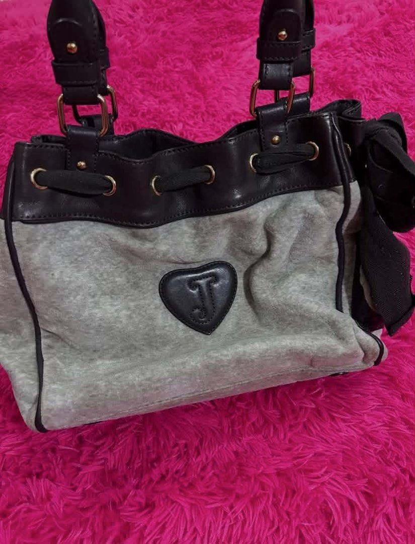 Juicy Couture grey and black velour shoulder bag (Category: Shoulder Bags) located in Carmen. Submitted by juicy_thangs (Listing ID 1471069447, Image 3). Description: - Brand: Juicy Couture - Color: Grey velour with black faux leather trim - Design: Front embroidered crest patch with crown and heart; back heart-shaped patch with raised J logo - Features: Dual top handles, side pocket, and attached ribbon accent - Hardware: Gold-tone throughout - 