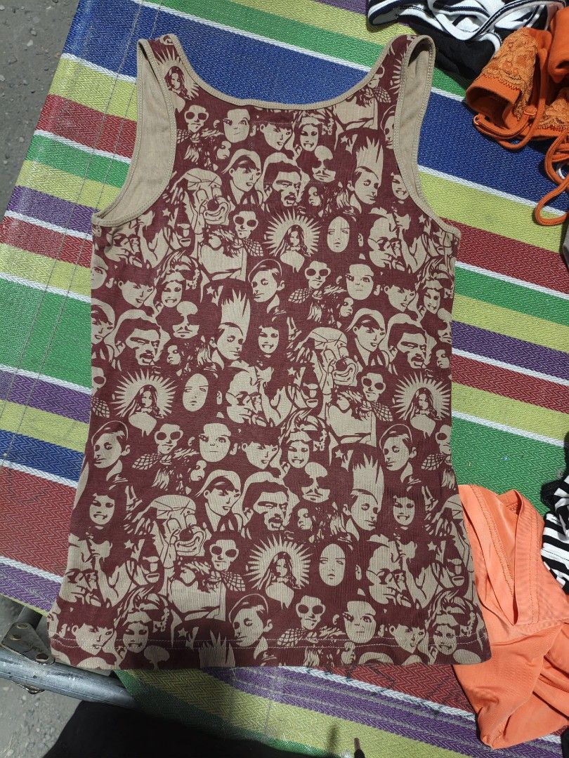 Kama Classics All-Over Face Print Tank Top Size M (Category: Sleeveless) located in Maasim. Submitted by ukayganda25 (Listing ID 1471101564, Image 2). Description: - Brand: Kama Classics - Design: Retro all-over face print in burgundy and tan - Size: Medium (tag on collar) - Material: 100% cotton (soft and breathable) - Details: Scoop neckline and standard ribbed armholes - Condition: Great vintage-style piece.