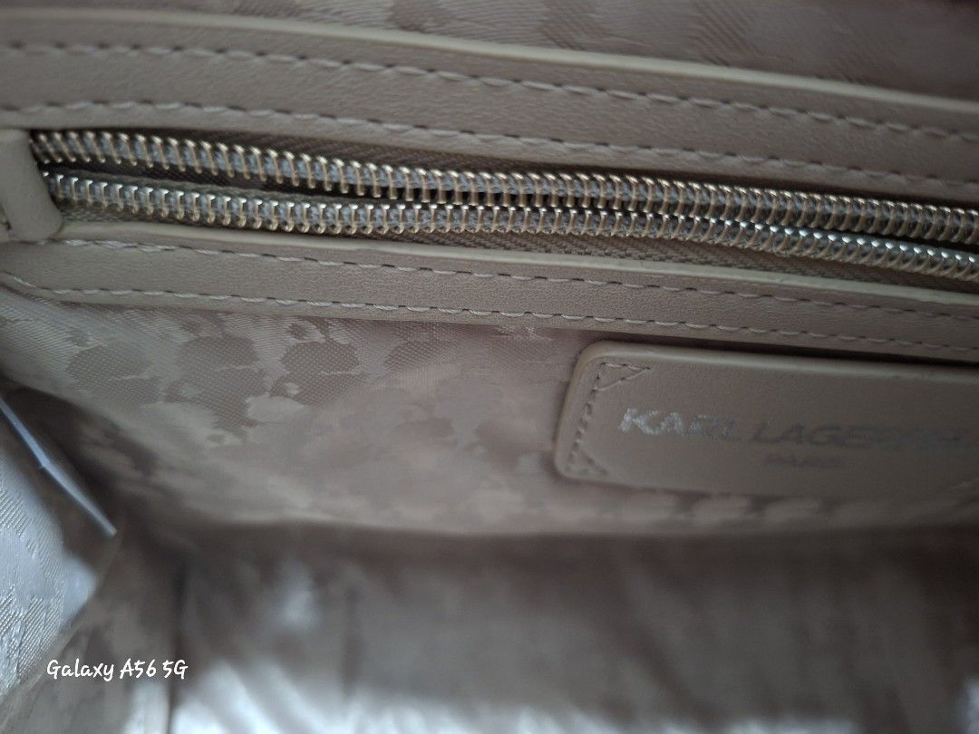 Karl Lagerfeld Paris Winter White Handbag (Category: Shoulder Bags) located in Cavite. Submitted by lvjohnsen (Listing ID 1471055859, Image 3). Description: - Brand: Karl Lagerfeld Paris - Color: Winter White - Condition: Brand new with original tags attached (MSRP $198) - Design: Cute Karl and Choupette graphic appliques on the front - Structure: Structured shape with double top handles and protective metal feet on the bottom - Interior: Feature