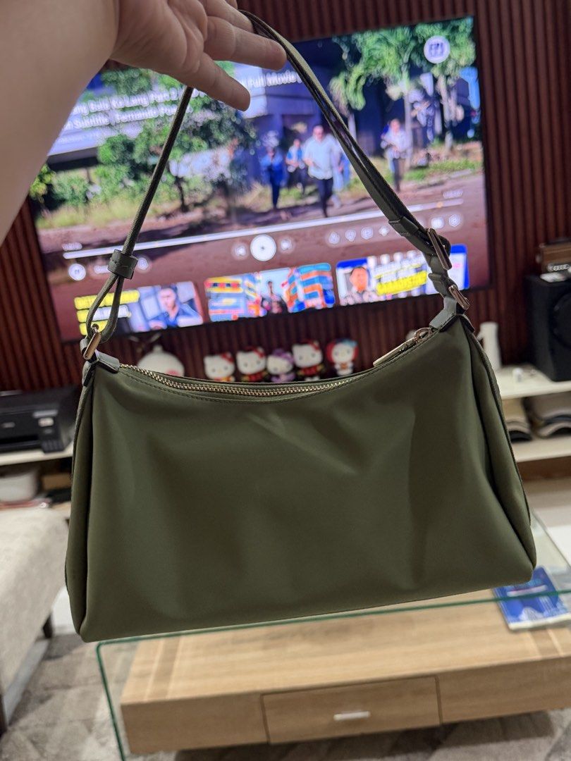 Kate Spade Green Nylon Shoulder Bag (Category: Luxury Bags & Wallets) located in Manila. Submitted by wildstorm.986cf1 (Listing ID 1470971593, Image 2). Description: - Brand: Kate Spade New York - Color: Olive Green - Material: Durable and lightweight nylon - Closure: Secure top zipper - Details: Front metal logo plaque - Strap: Matching green strap with side adjustable buckles - Condition: Clean, practical, and ideal for daily use.