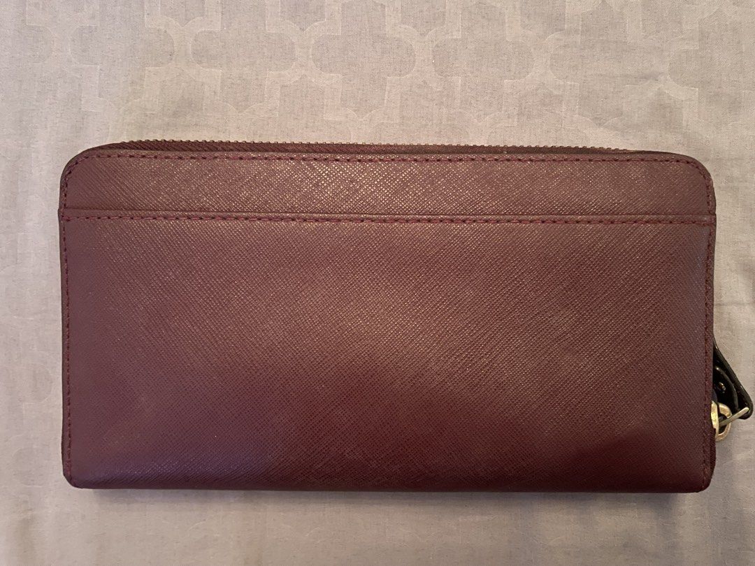 Kate Spade Zip Around Wallet Burgundy (Category: Wallets & Card holders) located in Manila. Submitted by azishops (Listing ID 1471023848, Image 2). Description: - Brand: Kate Spade - Material: Durable Saffiano leather in a rich burgundy color - Hardware: Gold-tone hardware with front metal logo plaque - Interior: Multiple card slots, slip pockets, and a secure zippered coin compartment - Lining: Signature patterned fabric - Inclusions: Original g