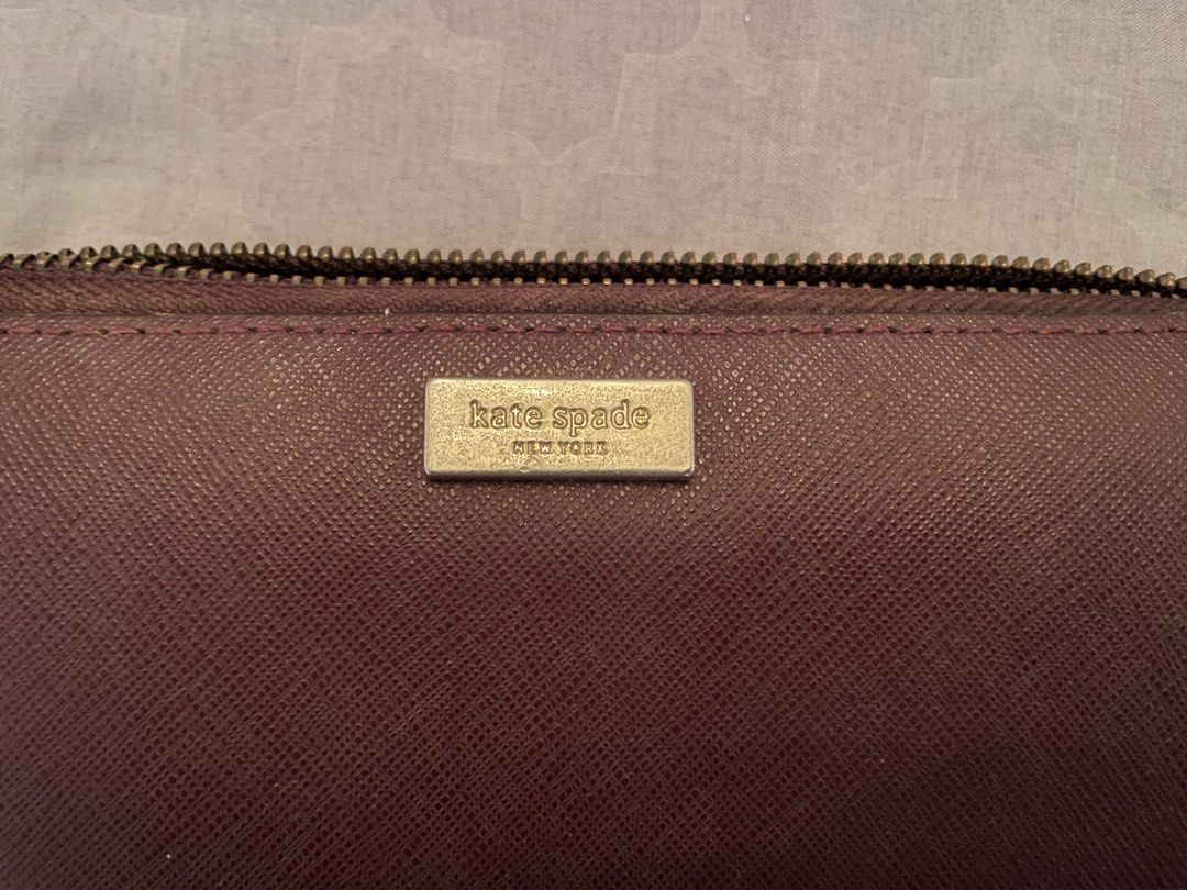 Kate Spade Zip Around Wallet Burgundy (Category: Wallets & Card holders) located in Manila. Submitted by azishops (Listing ID 1471023848, Image 3). Description: - Brand: Kate Spade - Material: Durable Saffiano leather in a rich burgundy color - Hardware: Gold-tone hardware with front metal logo plaque - Interior: Multiple card slots, slip pockets, and a secure zippered coin compartment - Lining: Signature patterned fabric - Inclusions: Original g