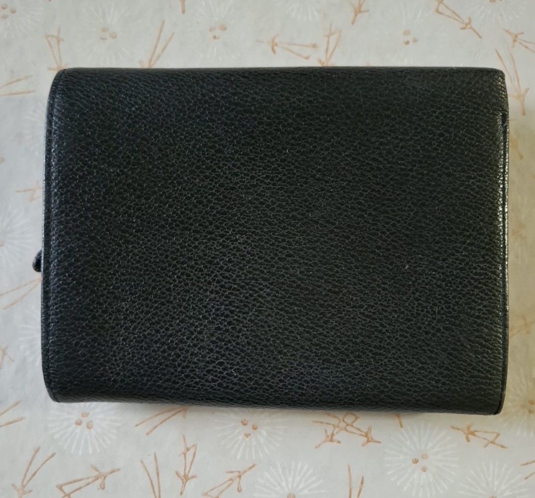 Kenzo Black Leather Wallet with Floral Interior (Category: Wallets & Card holders) located in Don Carlos. Submitted by PphiXi_Finds (Listing ID 1470942052, Image 2). Description: - Brand: Kenzo - Material: Black textured leather with gold-tone logo lettering - Interior: Vibrant colorful floral print lining - Features: Card slots, cash compartments, and a secure zippered coin pocket - Closure: Gold snap button - Size: Compact and handy for everyda