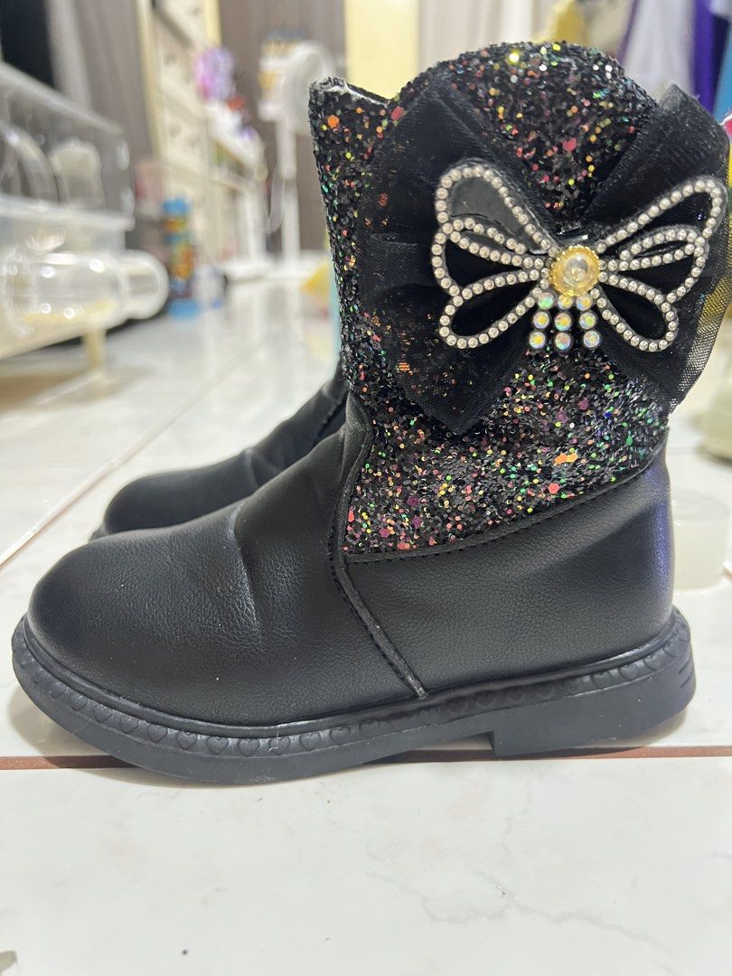 Kids boots (Category: Babies & Kids Fashion) located in Caloocan City. Submitted by verygoodmama (Listing ID 1471080128, Image 1). Description: Kids Black Glitter Boots 🎀 Size 29 | 20 cm outsole Once lang nagamit ng anak ko. May cute glitter and ribbon details. Please check photos for actual condition. 📍 Caloocan Monumento 🚚 Lalamove or GNT ❌ No COD.