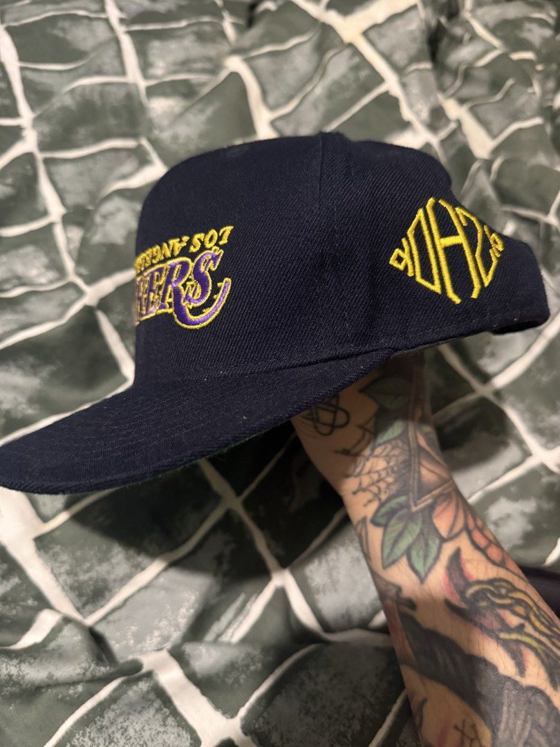 Kill The Hype Los Angeles Lakers Snapback Hat (Category: Caps & Hats) located in Manila. Submitted by safeowl.b6dbb0 (Listing ID 1471023772, Image 3). Description: - Brand: Kill The Hype (KTH) - Style: Los Angeles Lakers Snapback Cap - Color: Navy blue with green undervisor - Front Design: Upside-down Lakers embroidery in yellow and purple - Side Detail: Yellow KTH logo embroidery - Back Detail: White Kill The Hype embroidery above the adjustable