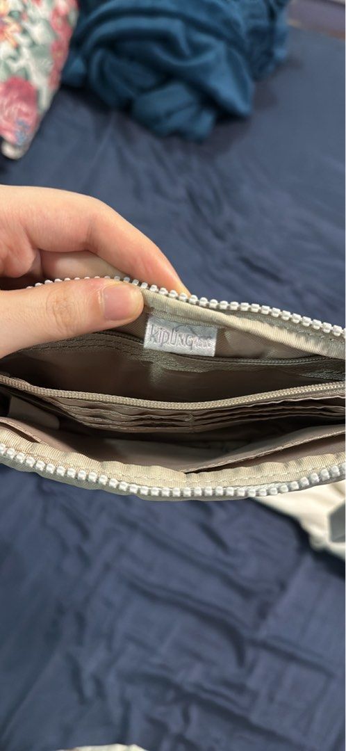Kipling Metallic Grey Wristlet Wallet Organizer (Category: Wallets & Card holders) located in Mabalacat. Submitted by mykachika (Listing ID 1471042777, Image 3). Description: - Authentic Kipling wristlet wallet in a stylish metallic grey finish - Secure zip-around closure with a handy detachable wrist strap - Well-organized interior featuring multiple card slots, slip pockets, and a zippered coin compartment - Clean lining and smooth-working zipp