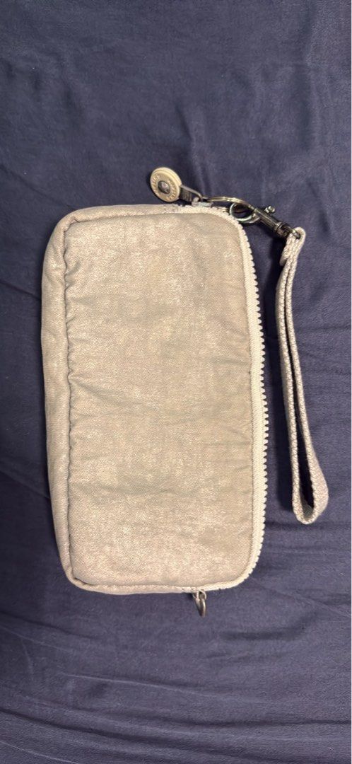 Kipling Metallic Grey Wristlet Wallet Organizer (Category: Wallets & Card holders) located in Mabalacat. Submitted by mykachika (Listing ID 1471042777, Image 2). Description: - Authentic Kipling wristlet wallet in a stylish metallic grey finish - Secure zip-around closure with a handy detachable wrist strap - Well-organized interior featuring multiple card slots, slip pockets, and a zippered coin compartment - Clean lining and smooth-working zipp
