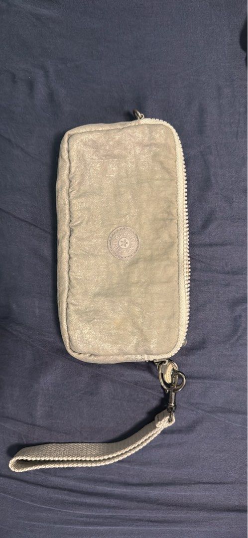 Kipling Metallic Grey Wristlet Wallet Organizer (Category: Wallets & Card holders) located in Mabalacat. Submitted by mykachika (Listing ID 1471042777, Image 1). Description: - Authentic Kipling wristlet wallet in a stylish metallic grey finish - Secure zip-around closure with a handy detachable wrist strap - Well-organized interior featuring multiple card slots, slip pockets, and a zippered coin compartment - Clean lining and smooth-working zipp