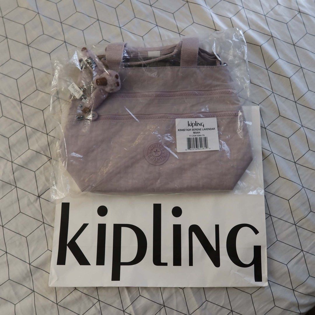 Kipling Miah Serene Lavender Tote Bag (Category: Tote Bags) located in Manila. Submitted by mixi_lexi (Listing ID 1471048306, Image 1). Description: - Brand: Kipling Miah Tote Bag - Color: Serene Lavender (Style Code: KI9462) - Material: Durable signature crinkle nylon - Features: Multiple zippered front compartments & top carry handles - Includes: Iconic furry purple monkey keychain charm - Condition: Brand new in original plastic packaging with