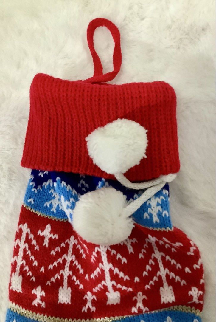 Knitted Christmas Stocking Fair Isle Holiday Decor (Category: Handmade Craft) located in Quezon City. Submitted by heybailey (Listing ID 1471003140, Image 2). Description: DIMENSIONS WIDTH: 5 inches LENGTH: 23 inches - Festive Christmas stocking with a classic Fair Isle geometric and pine tree pattern - Vibrant color combination of green, blue, red, and white - Features a cozy red cuff and playful dangling white pom-poms - Built-in hanging loop f