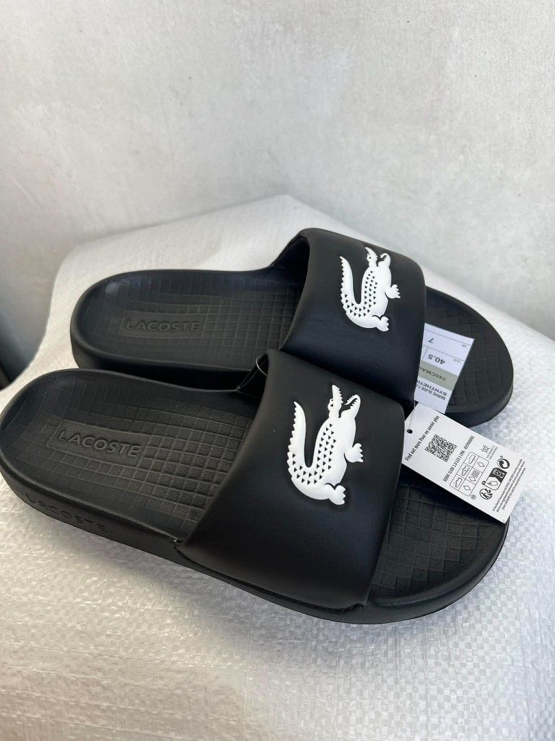 Lacoste Serve Slide 1.0 Black White (Category: Slippers & Slides) located in General Mariano Alvarez. Submitted by deslacbayan (Listing ID 1471054184, Image 2). Description: - Brand: Lacoste Serve Slide - Color: Black with white crocodile logo - Size: EU 40.5, US 8, UK 7 - Condition: Brand new with original tag attached - Features: Textured footbed for grip, synthetic material - Status: Clean pair, ready to wear - Available Sizes from 6 to 11 Col