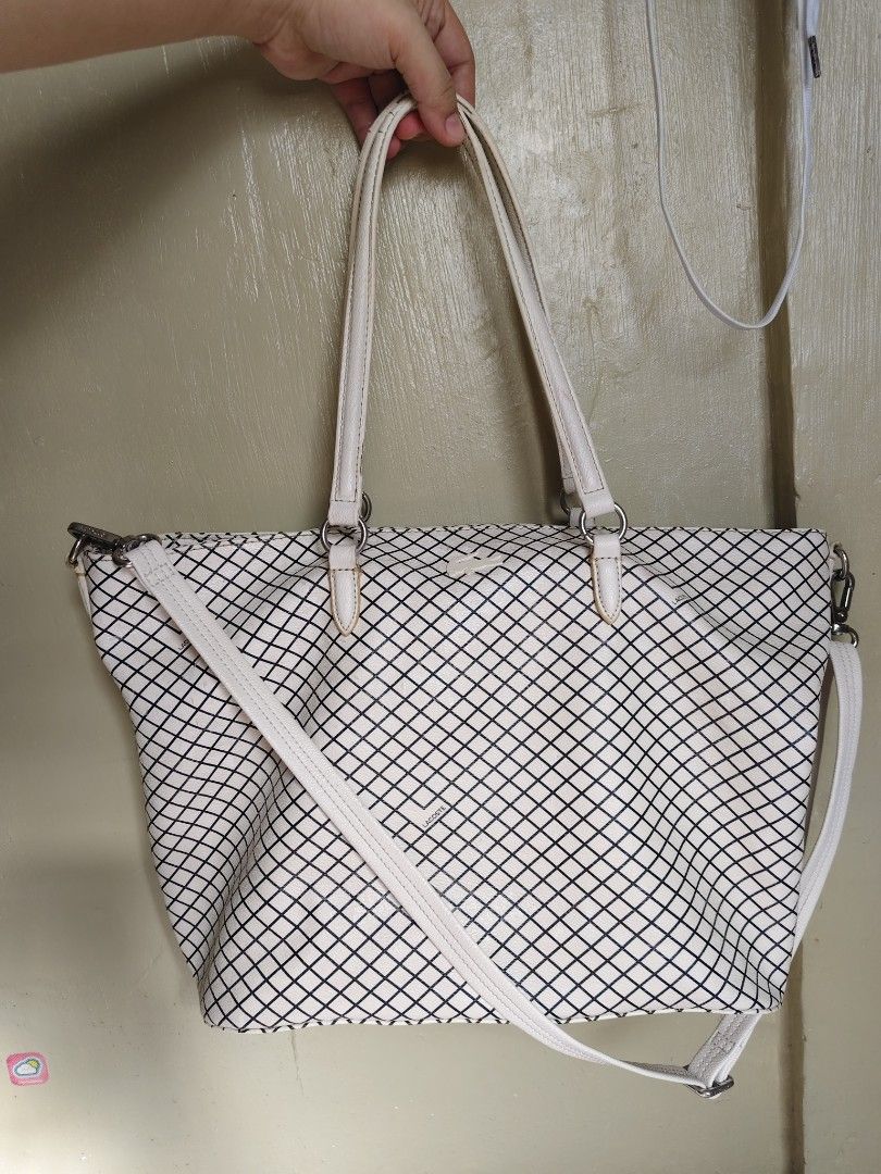 Lacoste White Black Grid Tote Bag Shoulder Bag (Category: Tote Bags) located in General Mariano Alvarez. Submitted by findsandmoreph (Listing ID 1470993726, Image 1). Description: - Brand: Lacoste - Design: White tote bag with an all-over black grid pattern - Hardware: Silver-tone hardware and clips - Straps: Dual top handles and a convenient detachable shoulder strap - Closure: Secure top zipper closure - Condition: Some yellowing and minor wear