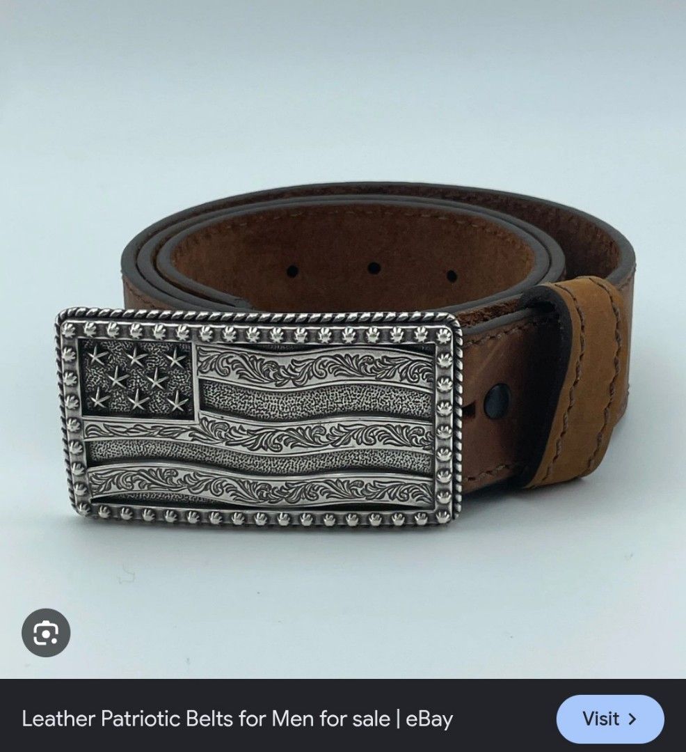 Leather Belt With American Flag Buckle (Category: Belts) located in Imus. Submitted by darylg88358770 (Listing ID 1471023278, Image 1). Description: - Style: Classic Western style - Strap: Genuine brown leather with sturdy edge stitching - Buckle: Silver-tone metal plate featuring an embossed American flag, stars, and floral scroll patterns - Closure: Standard pin buckle on the back - the items trifted fresh from bale size 34 .