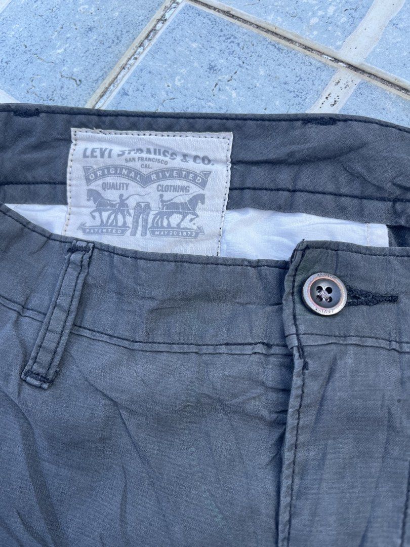 Levi's Dark Grey Cargo Shorts (Category: Shorts) located in Leyte. Submitted by odd_noodle (Listing ID 1470988499, Image 2). Description: - Brand: Levi Strauss & Co. - Color: Dark Grey - Material: 100% durable cotton - Pockets: Multiple utility pockets with secure snap-button closures on sides and back, plus branded inner pocket graphics - Fit: Classic waistband with belt loops and button fly fastening - Style: Casual everyday wear, versatile and