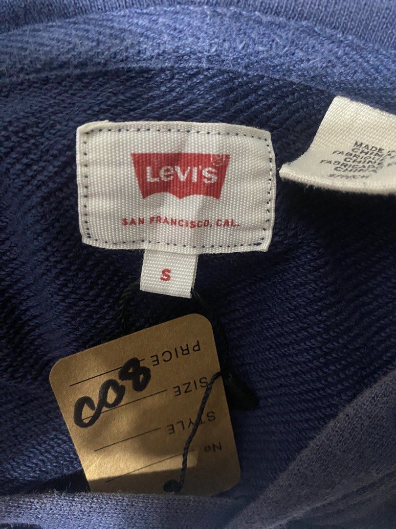 Levi's Navy Blue Hoodie Size S (Category: Coats, Jackets and Outerwear) located in Manila. Submitted by cj_thrift10 (Listing ID 1471051501, Image 2). Description: - Brand: Levi's - Color: Navy Blue with classic red front logo graphic - Size: Small (Tag shows 165/84A) - Material: Soft cotton blend, ideal for cooler weather - Features: Drawstring hood and front kangaroo pocket - Condition: Brand new with tag attached.