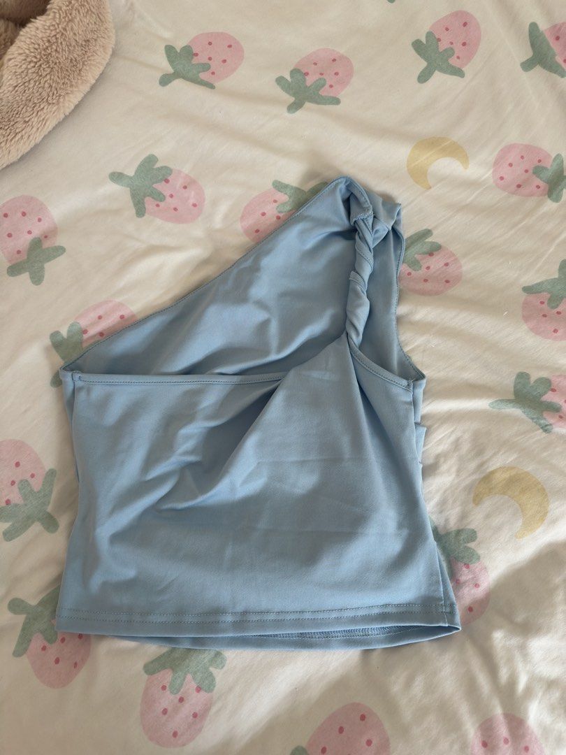 Light blue one-shoulder crop top with twisted strap (Category: Sleeveless) located in Manila. Submitted by preloved-bycath (Listing ID 1471078866, Image 2). Description: - Color: Light blue - Style: One-shoulder crop top with twisted strap on the right - Fit: Fitted silhouette with a straight hemline - Material: Soft and stretchy fabric - Best paired with: High-waisted denim shorts or skirts - Occasion: Casual wear, perfect for warm weather.
