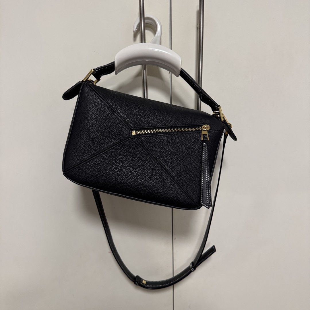 Loewe Puzzle Bag Black Leather (Category: Luxury Bags & Wallets) located in Manila. Submitted by caramelbliss (Listing ID 1471040707, Image 3). Description: - Loewe Puzzle bag in black grained leather - Iconic geometric panel design with chic contrast white stitching - Premium gold-tone hardware and embossed Anagram logo - Comes with an adjustable and detachable shoulder strap - Maintains a clean, structured shape and holds its form well - Condit
