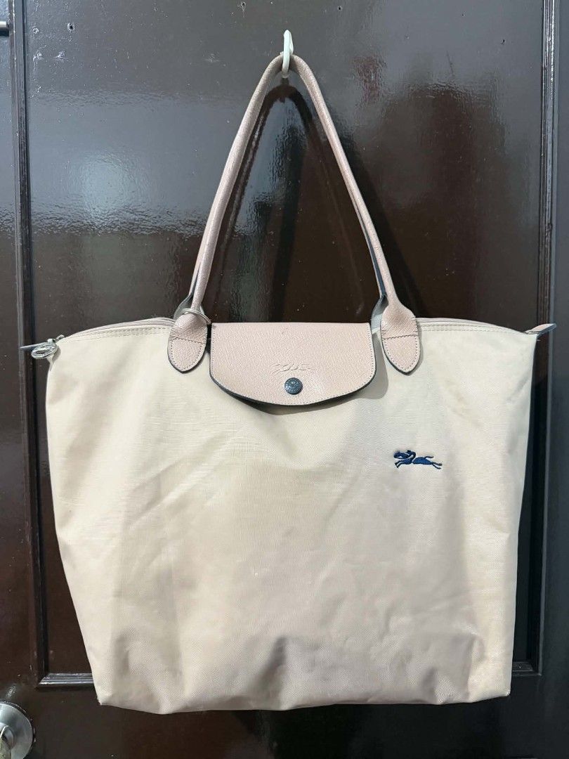 Longchamp Le Pliage Medium Beige Tote Bag (Category: Luxury Bags & Wallets) located in Quezon City. Submitted by skyleeeee (Listing ID 1470985298, Image 1). Description: - Brand: Longchamp Le Pliage - Style: Medium shoulder bag / everyday tote - Color: Beige nylon with brown leather trim - Details: Zipper top with metal horse pull tab, snap button closure, back exterior pocket - Branding: Navy embroidered horse logo on the front - Condition: Mino