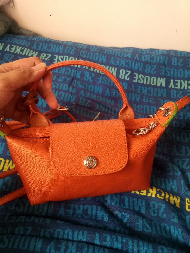 Longchamp Orange Nylon Crossbody Handbag (Category: Luxury Bags & Wallets) located in Manila. Submitted by littlelove25 (Listing ID 1470989112, Image 2). Description: - Vibrant bright orange nylon material with leather flap and snap button closure - Features silver-tone hardware with signature horse logo zipper pull - Compact size, perfect for carrying daily essentials - Versatile design with top handle and a long adjustable strap included.