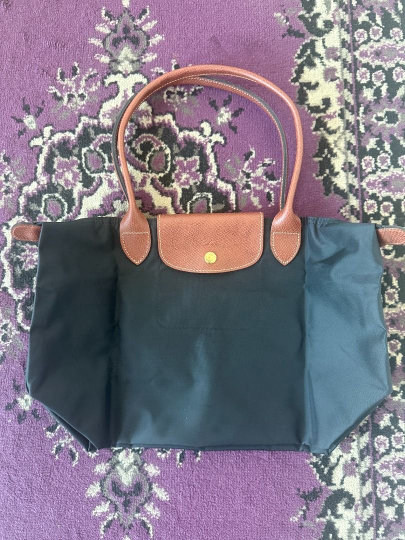 Longchamp Paris Nylon Tote Bag (Category: Luxury Bags & Wallets) located in Quezon City. Submitted by articolipreamati (Listing ID 1470997715, Image 1). Description: - Brand: Longchamp Paris - Style: Classic everyday tote / shoulder bag - Color: Black with brown leather handles and flap closure - Hardware: Gold-tone hardware with signature horse logo zipper pull - Interior: Spacious main compartment - Authenticity details: Inside tag includes mod