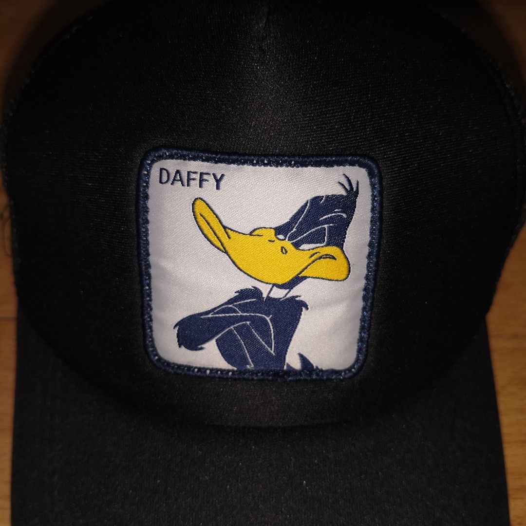 Looney Tunes Daffy Duck Trucker Cap (Category: Caps & Hats) located in Manila. Submitted by usedtobeyours26 (Listing ID 1471073946, Image 2). Description: - Daffy Duck front patch graphic - Breathable black mesh back panels - Adjustable plastic snapback closure for a customized fit - Eye-catching yellow and black side embroidery - Classic curved brim and structured front foam panel - Condition: Excellent .