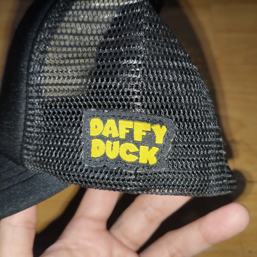 Looney Tunes Daffy Duck Trucker Cap (Category: Caps & Hats) located in Manila. Submitted by usedtobeyours26 (Listing ID 1471073946, Image 3). Description: - Daffy Duck front patch graphic - Breathable black mesh back panels - Adjustable plastic snapback closure for a customized fit - Eye-catching yellow and black side embroidery - Classic curved brim and structured front foam panel - Condition: Excellent .