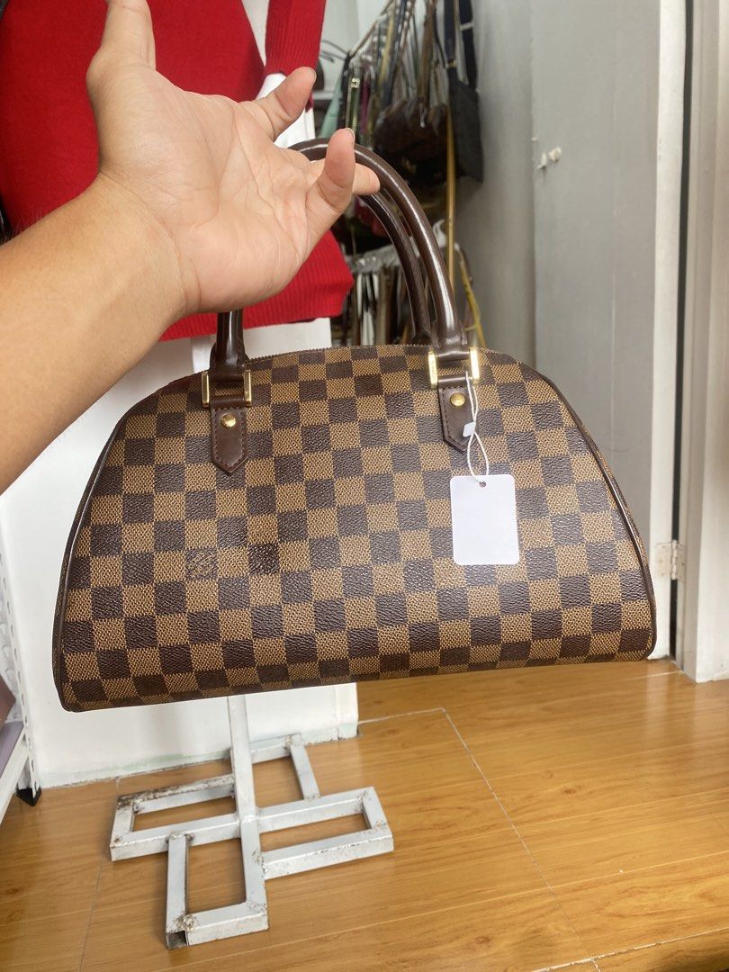 Louis Vuitton Damier Ebene Handbag (Category: Luxury Bags & Wallets) located in San Fernando. Submitted by thrifteezy6 (Listing ID 1470961057, Image 3). Description: - Iconic Brown Damier Ebene checkered canvas - Premium dark brown leather top handles - Elegant gold-tone hardware with LV-stamped zipper pullers - Secure full zip-around closure - Structured silhouette with a flat base for easy storage - 100% authentic and well-maintained - Message 