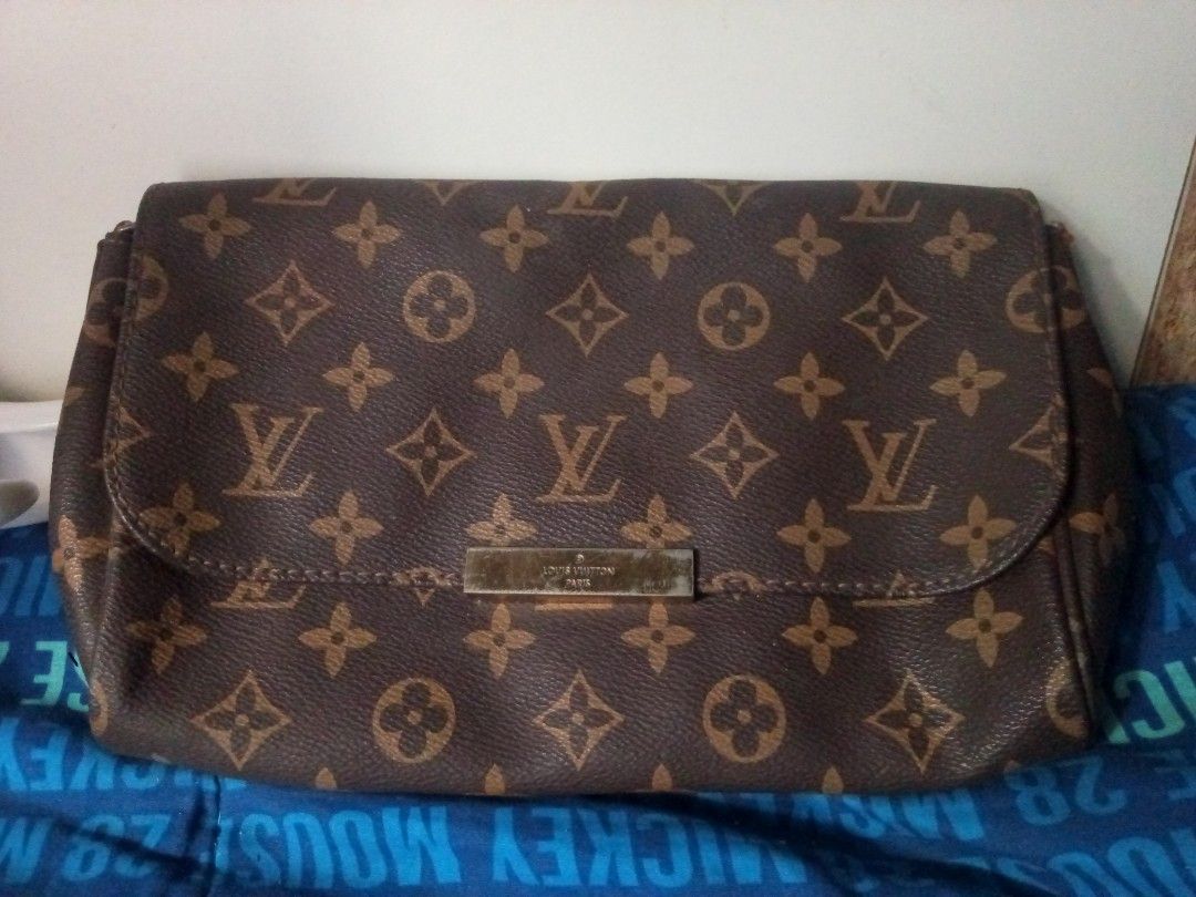 Louis Vuitton Monogram Flap Crossbody Bag (Category: Luxury Bags & Wallets) located in Manila. Submitted by littlelove25 (Listing ID 1471030989, Image 1). Description: - Brand: Louis Vuitton - Style: Monogram canvas flap bag with gold-tone hardware plate - Inclusions: Attached leather shoulder strap and chain detail - Condition: Noticeable wear and fraying near the side attachment loops, with heavy scratches on the front metal plate - Perfect for