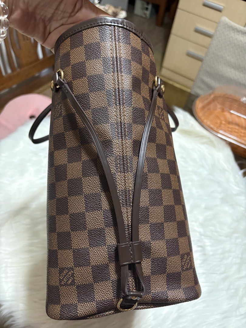 Louis Vuitton Neverfull MM Damier Ebene Tote (Category: Luxury Bags & Wallets) located in Mandaue City. Submitted by jane2872 (Listing ID 1470993665, Image 3). Description: - Authentic Louis Vuitton Neverfull MM in classic Damier Ebene canvas - Vibrant red interior lining with clean handles and sturdy leather trim - Includes a matching Samorga red felt organizer insert to keep your things neat - Comes with original dust bag, tags, and a bonus red