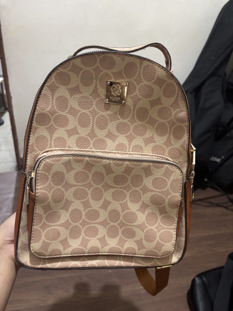 Lucile Monogram Print Casual Backpack Brown Cream (Category: Backpacks) located in Manila. Submitted by elyxbns (Listing ID 1471030563, Image 1). Description: - Brand/Model: Lucile Monogram Backpack - Color: Brown and Cream - Hardware: Gold-toned - Features: Front zip pocket, top handle, and adjustable shoulder straps - Condition: Clean inside and out, sturdy and smooth-working zippers.
