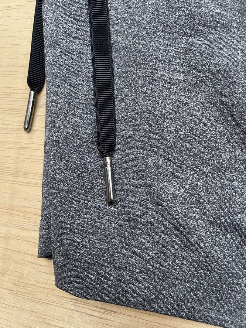Lululemon Athletic Shorts Size 4 Grey (Category: Shorts) located in Cebu City. Submitted by pinoclifford (Listing ID 1471041244, Image 3). Description: - Brand: Lululemon - Color: Heathered Grey - Size: 4 - Material: Nylon, polyester, and lycra elastane blend - Features: Elastic waistband, adjustable black drawstring with branded metal tips - Details: Small reflective logo on the lower left hem and multiple convenient pockets.