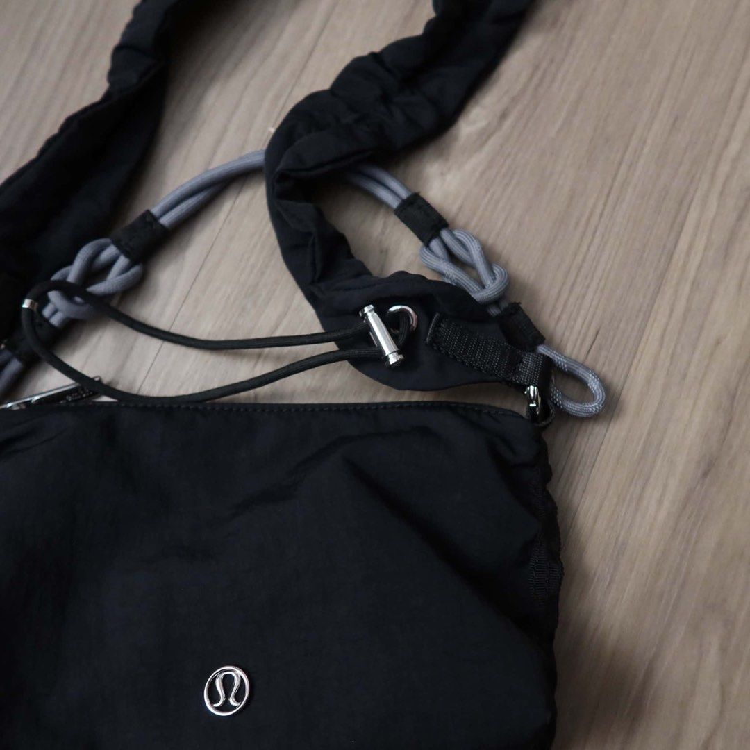 Lululemon Black Shoulder Bag (Category: Shoulder Bags) located in Manila. Submitted by mixi_lexi (Listing ID 1471050127, Image 3). Description: - Brand: Lululemon - Style: Shoulder bag / Crossbody - Color: Black with silver-tone hardware - Material: Durable nylon - Dimensions: 13 x 21 cm - Straps included: Gathered black strap and an extra grey knotted rope handle - Condition: Clean interior lining with tag intact - Perfect for daily errands, cas