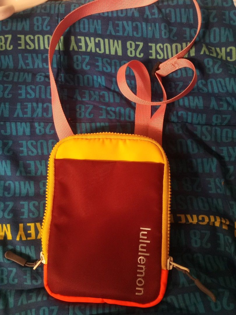 Lululemon Multicolor Crossbody Phone Pouch Bag (Category: Cross-body Bags) located in Manila. Submitted by littlelove25 (Listing ID 1471005996, Image 1). Description: Lululemon crossbody pouch bag. Multi-color design with yellow, red, and pink strap. Adjustable and detachable strap with black clips. Zip around closure, interior slip pockets, and brand logo on the front. Nylon material, lightweight and compact. Interior tag shows product details..