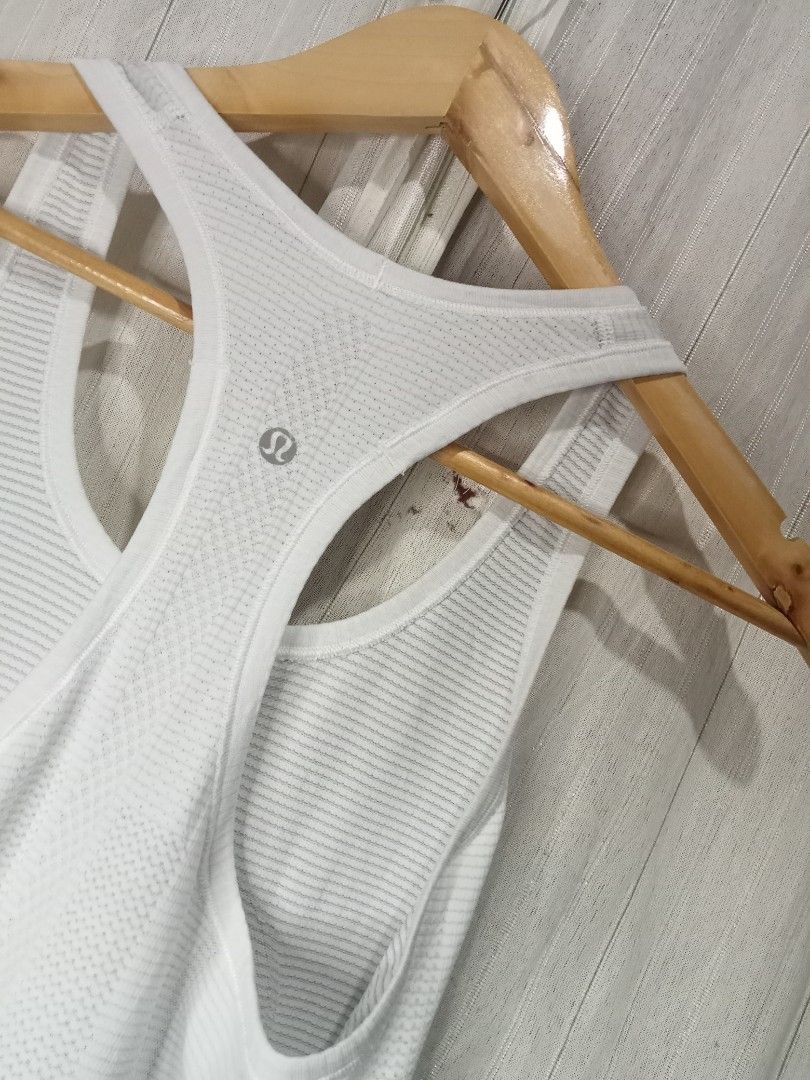 Lululemon White Racerback Tank Top (Category: Activewear) located in Bais. Submitted by gelothrifts (Listing ID 1470988352, Image 2). Description: - Brand: Lululemon - Color: Solid White - Design: Racerback with scoop neckline (front and back) - Features: Breathable knit patterns and lightweight seamless stretch fabric - Detail: Classic silver signature logo on the upper back - Condition: Excellent, well-maintained - Perfect for: Gym workouts, yo