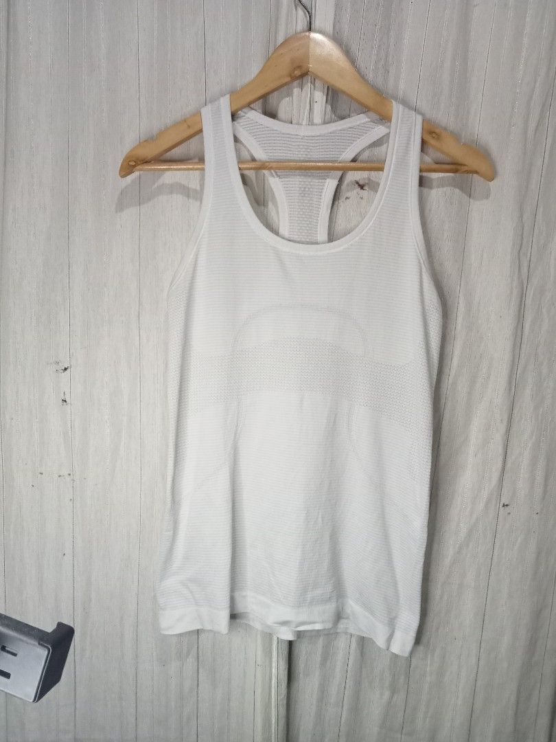 Lululemon White Racerback Tank Top (Category: Activewear) located in Bais. Submitted by gelothrifts (Listing ID 1470988352, Image 1). Description: - Brand: Lululemon - Color: Solid White - Design: Racerback with scoop neckline (front and back) - Features: Breathable knit patterns and lightweight seamless stretch fabric - Detail: Classic silver signature logo on the upper back - Condition: Excellent, well-maintained - Perfect for: Gym workouts, yo