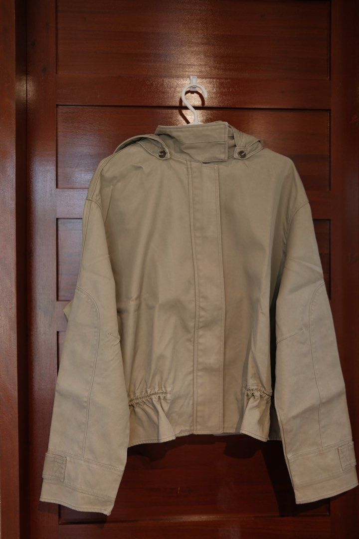 Mango Beige Hooded Jacket With Ruffled Hem (Category: Coats, Jackets and Outerwear) located in Makati City. Submitted by nomoreclutterph (Listing ID 1471048184, Image 1). Description: - Color: Versatile beige / neutral earth tone - Closure: Full front zipper with a button placket - Collar & Hood: High neckline with button closure and a removable hood (snap-on) - Fit & Style: Long sleeves with wide cuffs and a stylish ruffled hem with an adjustabl